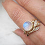 Load image into Gallery viewer, Model wearing a Misa Jewelry 14K yellow gold ring with a rose-cut rainbow moonstone and diamond halo stacked with a yellow gold band.
