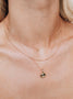 Load image into Gallery viewer, Model wearing Anzie Aztec Mini Locket necklace in yellow gold featuring an intricate engraved Aztec-inspired design with a diamond accent layered with other necklaces.
