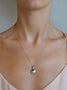 Load image into Gallery viewer, Model wearing Anzie Aztec Mini Locket necklace in yellow gold featuring an intricate engraved Aztec-inspired design with a diamond accent, elegant keepsake pendant jewelry for holding cherished memories close.