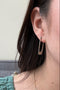 Load image into Gallery viewer, Model wearing handmade sterling silver rectangle hoop earrings by Philippa Roberts featuring a simple geometric design, made in Oakland, CA.

