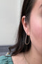Load image into Gallery viewer, Model wearing handmade sterling silver teardrop hoop earrings by Philippa Roberts featuring organically shaped hoops, made in Oakland, CA.

