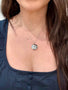 Load image into Gallery viewer, Model wearing Anzie sterling silver locket pendant necklace with white topaz and sapphires, suspended from a delicate silver chain.
