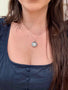 Load image into Gallery viewer, Model wearing Anzie sterling silver starburst locket with white sapphire center stone, photo pendant necklace designed to hold a treasured photograph or keepsake.
