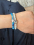 Load image into Gallery viewer, Model wearing Anzie blue ombré Afghanite rondelle beaded bracelet featuring natural Afghanite gemstone beads and a sterling silver hex bolt charm set with a clear topaz center, handcrafted designer gemstone jewelry bracelet stacked with other bracelets.
