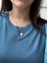 Load image into Gallery viewer, Model wearing the Anne Sportun Luna Seafoam Scattered Star Coin Charm on a chain necklace, showcasing the organic coin pendant with white and blue diamonds and blue sapphires.
