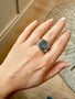 Load image into Gallery viewer, Model wearing sterling silver signet ring featuring an etched ocean wave on the face with engraved cranes decorating each side of the band.
