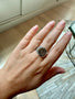Load image into Gallery viewer, Model wearing sterling silver signet ring by Digby &amp; Iona featuring an engraved All-Seeing Eye motif.
