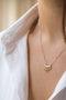Load image into Gallery viewer, Model wearing 14k light yellow gold Rising Sun necklace featuring white baguette diamonds arranged in a radiant sunburst design for a luminous, elegant look.
