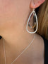 Load image into Gallery viewer, Model wearing Philippa Roberts Tear earrings in sterling silver with multicolored sapphires, handmade in Oakland, California.
