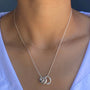Load image into Gallery viewer, Silver necklace with three rings worn by a model.
