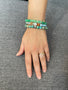 Load image into Gallery viewer, Model wearing Anzie turquoise jasper bracelet with 8mm round turquoise jasper beads, sterling silver hex bolt charm, and clear topaz accent stacked with other Anzie beaded bracelets. 
