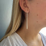 Load image into Gallery viewer, Model wearing handmade sterling silver long stick earrings by Philippa Roberts.
