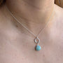 Load image into Gallery viewer, Model wearing circle amazonite pendant necklace in sterling silver featuring a round blue-green amazonite stone on a delicate cable chain with extender, handmade in Oakland, California.
