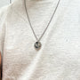 Load image into Gallery viewer, Model wearing a Digby &amp; Iona sterling silver necklace featuring a green moss agate pendant with a carved serpent and an engraved crow on a chain.
