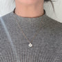 Load image into Gallery viewer, Model wearing Calla lily necklace in 14K yellow gold with mother of pearl pendant by Annette Ferdinandsen
