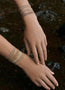 Load image into Gallery viewer, Close-up of hands wearing Marie Laure Chamorel multicolor woven bracelets with sterling silver chain and adjustable silk thread closure.
